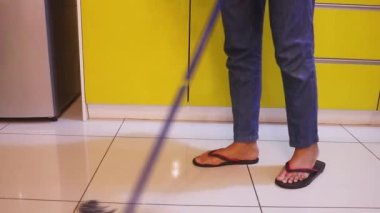 Young Woman Mopping The Kitchen Floor