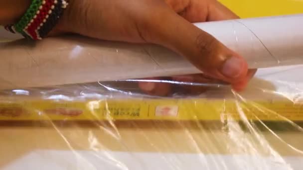 Cling Film Being Removed Ethnic Woman — Vídeo de stock