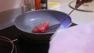 Ethnic Woman Pan Frying Salmon In A Pan