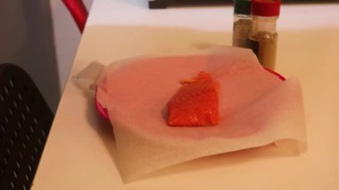 Ethnic Woman Preparing A Piece Of Salmon With Seasoning 