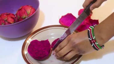 Ethnic Woman Slicing Dragon Fruits On A Plate 