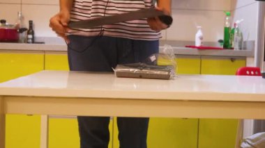 Ethnic Woman Taking A Trash Bag From A White Table