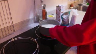 Müslüman kadın tavada makarna sosu yapıyor.