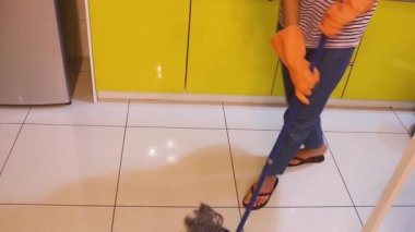 Mutfak zeminini paspaslayan Genç Kadın - Yüksek Açı.