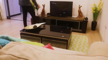 Kontrol Edilen Gömlekli Etnik Kadın TV setini kapatıyor.