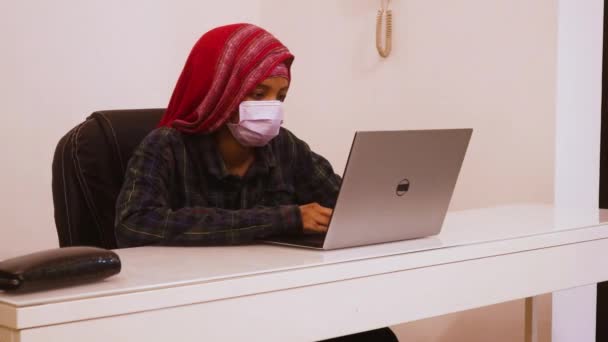 戴面具的少数民族妇女使用笔记本电脑 — 图库视频影像