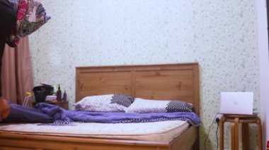 Yatak örtüleri genç Müslüman bir bayan tarafından onarılıyor.