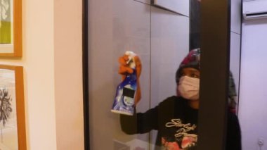 Cam Pencere Maskeli Kadın tarafından Siliniyor 