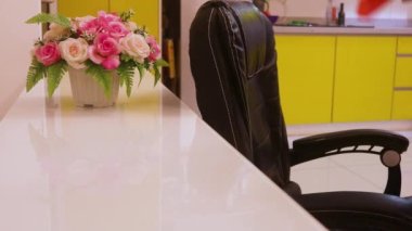 Temizlikçi Kadın Ofis Sandalyesini dezenfekte ediyor