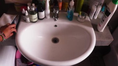 Kadının eli dişlerini fırçalamaya hazırlanıyor.