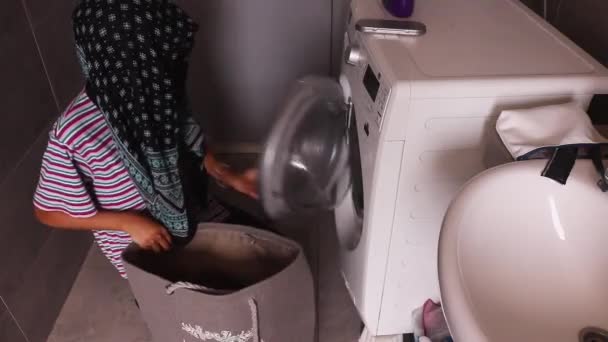 洗濯機のドアを閉めるイスラム教徒の女性と離れる 高角度 — ストック動画