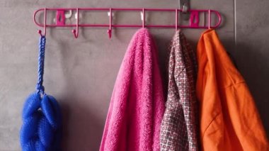 Banyodaki askıdan kıyafetlerini çıkaran kadın, ön manzara.