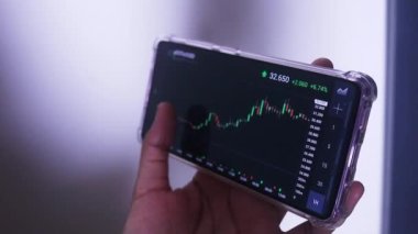 Woman Holding Phone In Landscape Mode Checking Polkadot's Hourly Chart