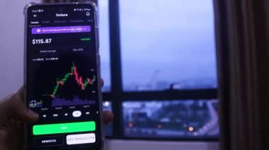 Woman With Tanned Hand Checking Solana Stocks In The Evening