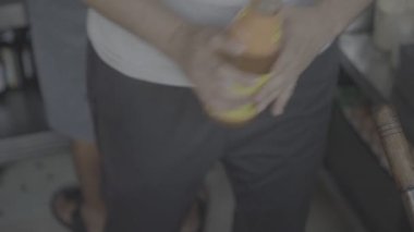 Çinli adam çorbaya sos ekliyor. 