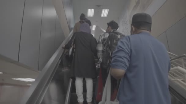 駅でエスカレーターを使用するマレーシアの男性と女性 — ストック動画