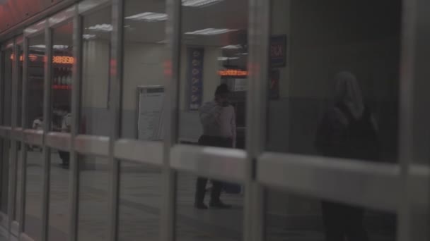 駅の中を歩くアジア系男性と女性の姿 — ストック動画