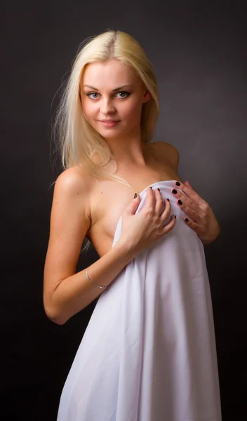 Topless blonde, covered with a white cloth on a black background — Stock Photo, Image