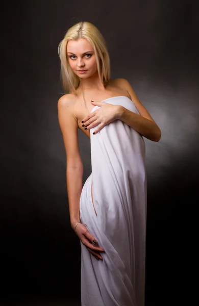 Topless blonde, covered with a white cloth on a black background — Stock Photo, Image