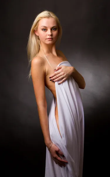 Topless blonde, covered with a white cloth on a black background — Stock Photo, Image