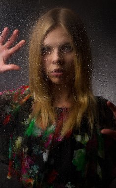 siyah zemin ıslak cam arkasında güzel bir kızın portresi.