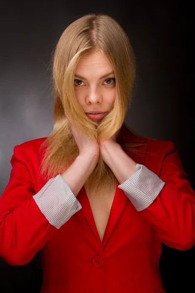 Beleza em uma jaqueta vermelha em um fundo preto . — Fotografia de Stock