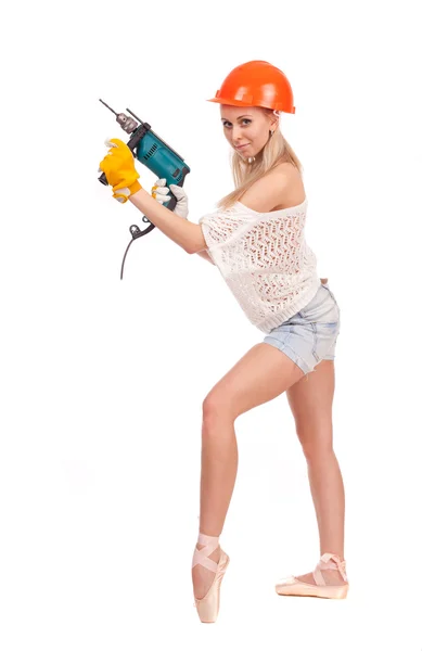 Worker in the form of a ballerina with an electric drill in orange helmet on white background. — Stock Photo, Image