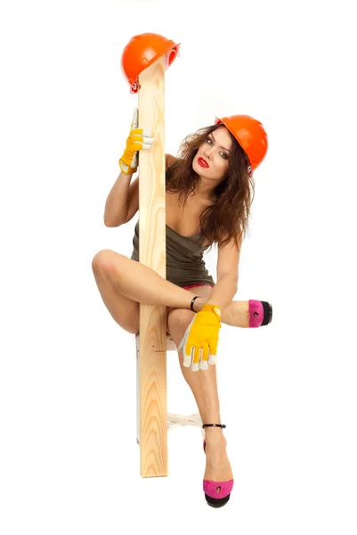 Half-naked beautiful girl in pink panties and orange hard hat on a white background. — Stock Photo, Image