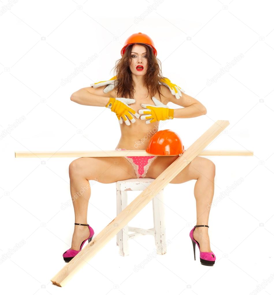 Half-naked beautiful girl in pink panties and orange hard hat on a white background.