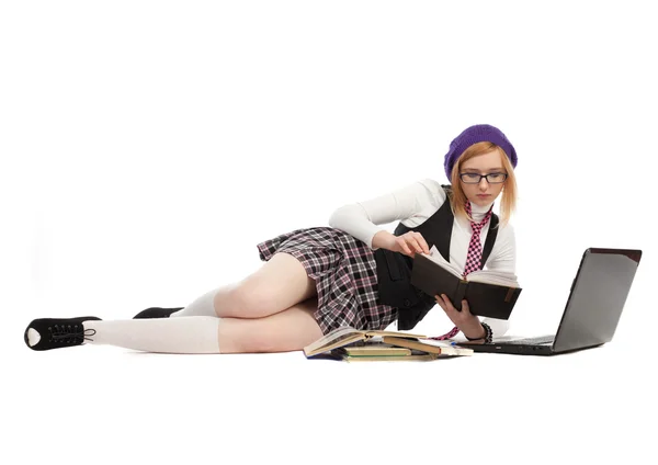 Ragazza con libri e laptop, sdraiata su uno sfondo bianco — Foto Stock