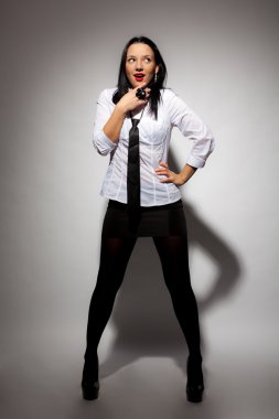 güzel kız beyaz bir gömlek ve gri bir arka plana sahip siyah bir etek