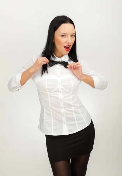 Schönes Mädchen in weißem Hemd und schwarzem Rock mit grauem Hintergrund — Stockfoto