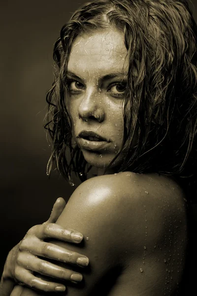 Retrato de la cara de una chica cuyo agua fluye sobre un fondo oscuro — Foto de Stock