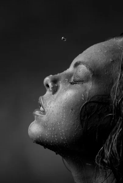 Retrato do rosto de uma menina que a água flui em um fundo escuro — Fotografia de Stock