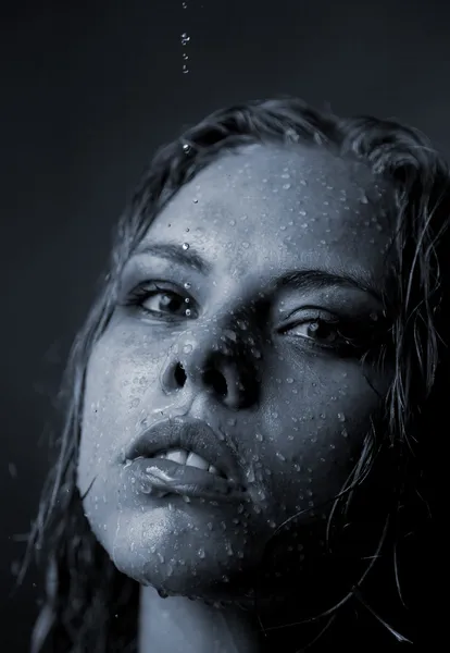 Retrato do rosto de uma menina que a água flui em um fundo escuro — Fotografia de Stock