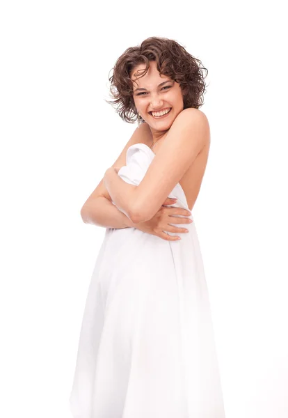 Una chica sonriente, vestida con una sábana blanca sobre un fondo blanco —  Fotos de Stock