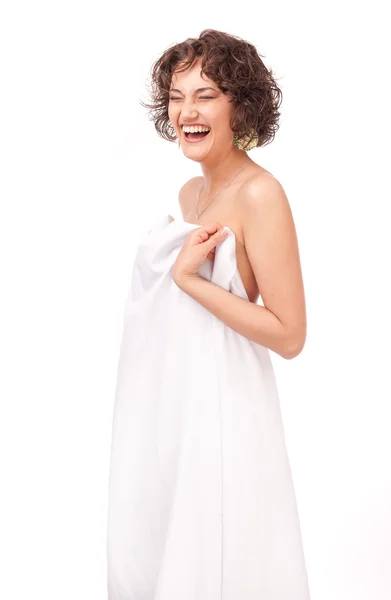 A smiling girl, clothed a white sheet on a white background — Stock Photo, Image