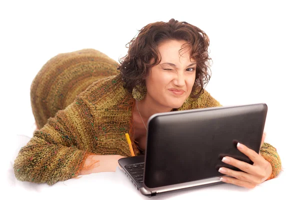 Knipogend op een meisje met een laptop op een witte achtergrond — Stockfoto