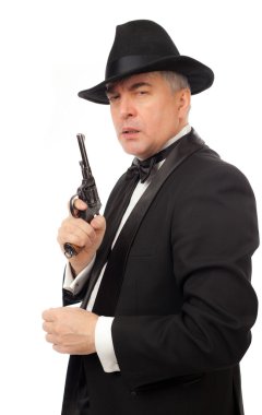 Smokin şapka ve beyaz zemin üzerine bir tabanca ile zarif adam