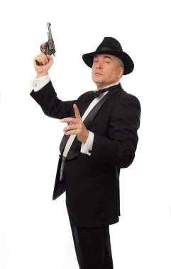 Smokin şapka ve beyaz zemin üzerine bir tabanca ile zarif adam
