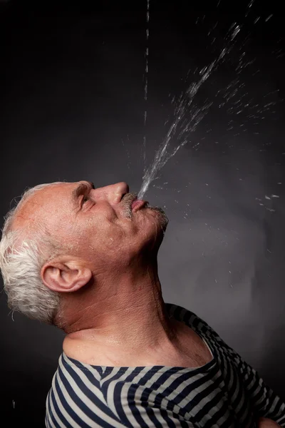 El hombre sobre el que derrama agua — Foto de Stock