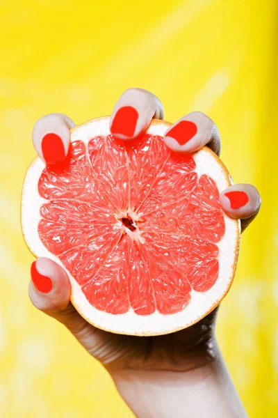 Kvinnan handen håller en grapefrukt — Stockfoto