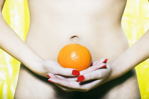 Mulher Abdômen segurando uma laranja — Fotografia de Stock