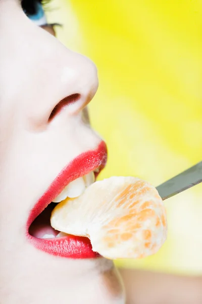 Vrouw staand eten een tangerine segment — Stockfoto