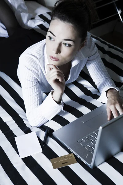 Woman in a bedroom computing thoughtful — Stock Photo, Image