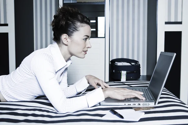 Kobieta w hotelu sypialnia komputera surfowania — Zdjęcie stockowe