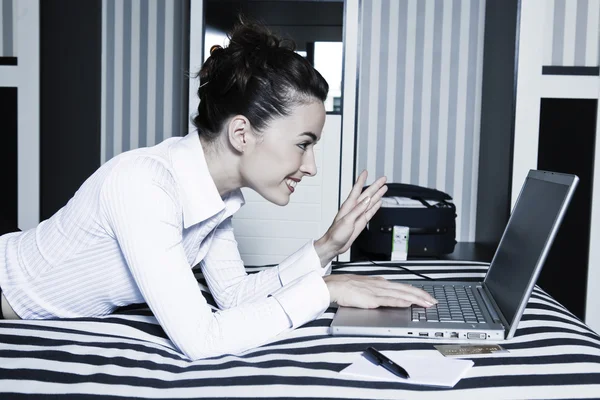 kadın bir otel yatak bilgisayar video konferans