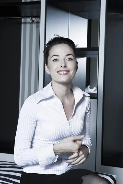 Vrouw staand glimlachend in een slaapkamer — Stockfoto