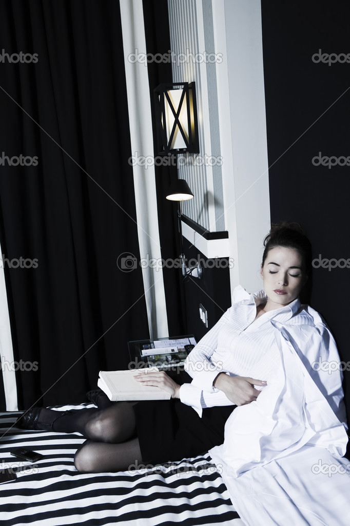 Woman reading asleep in a bedroom