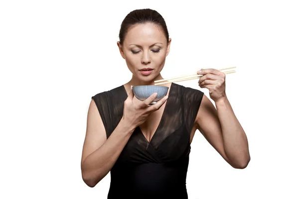 Портрет красивой женщины, кушающей с палочкой в миске — стоковое фото